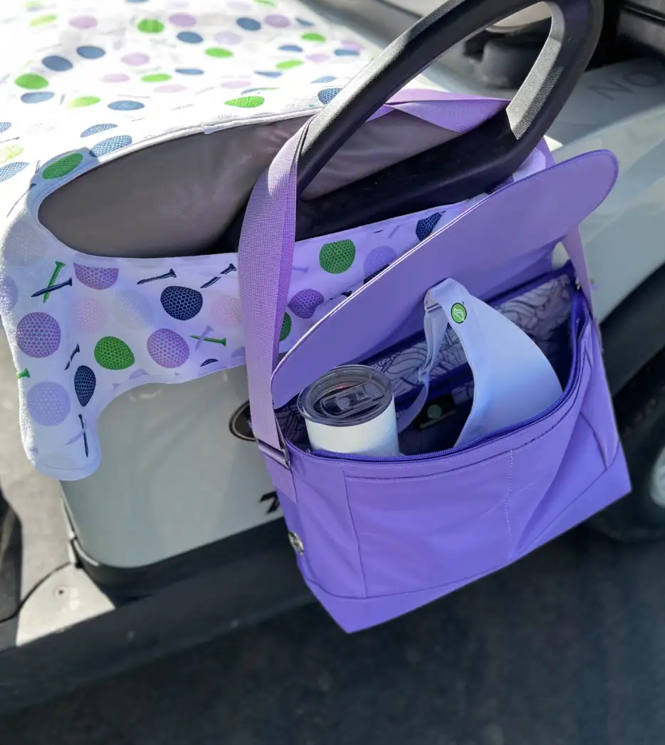 Purple golf bag organizer with a playful pattern of green, blue, and lavender golf balls and tees on the exterior fabric.